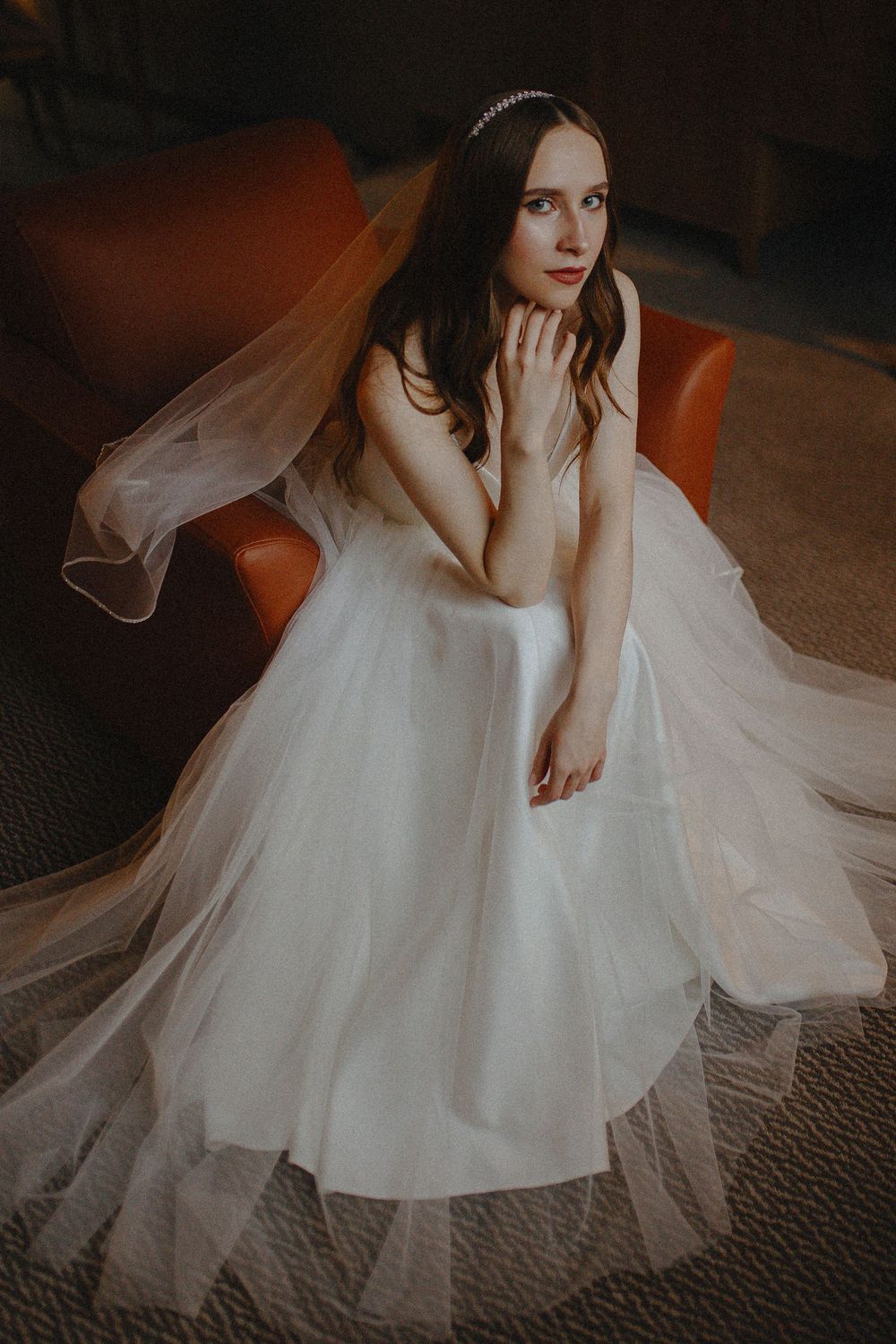 Artistic bridal portrait series showing flowing white wedding dress and veil details against dark moody lighting.