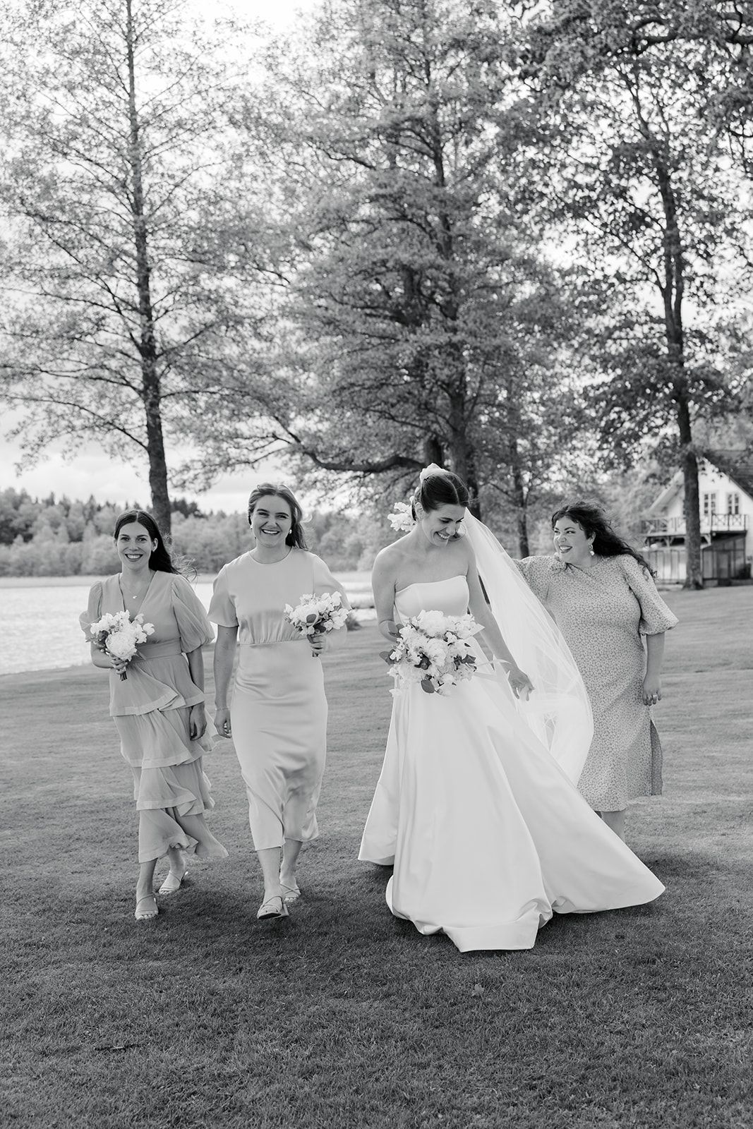 Wedding party walks together across a golf course casting long shadows on a sunny afternoon.