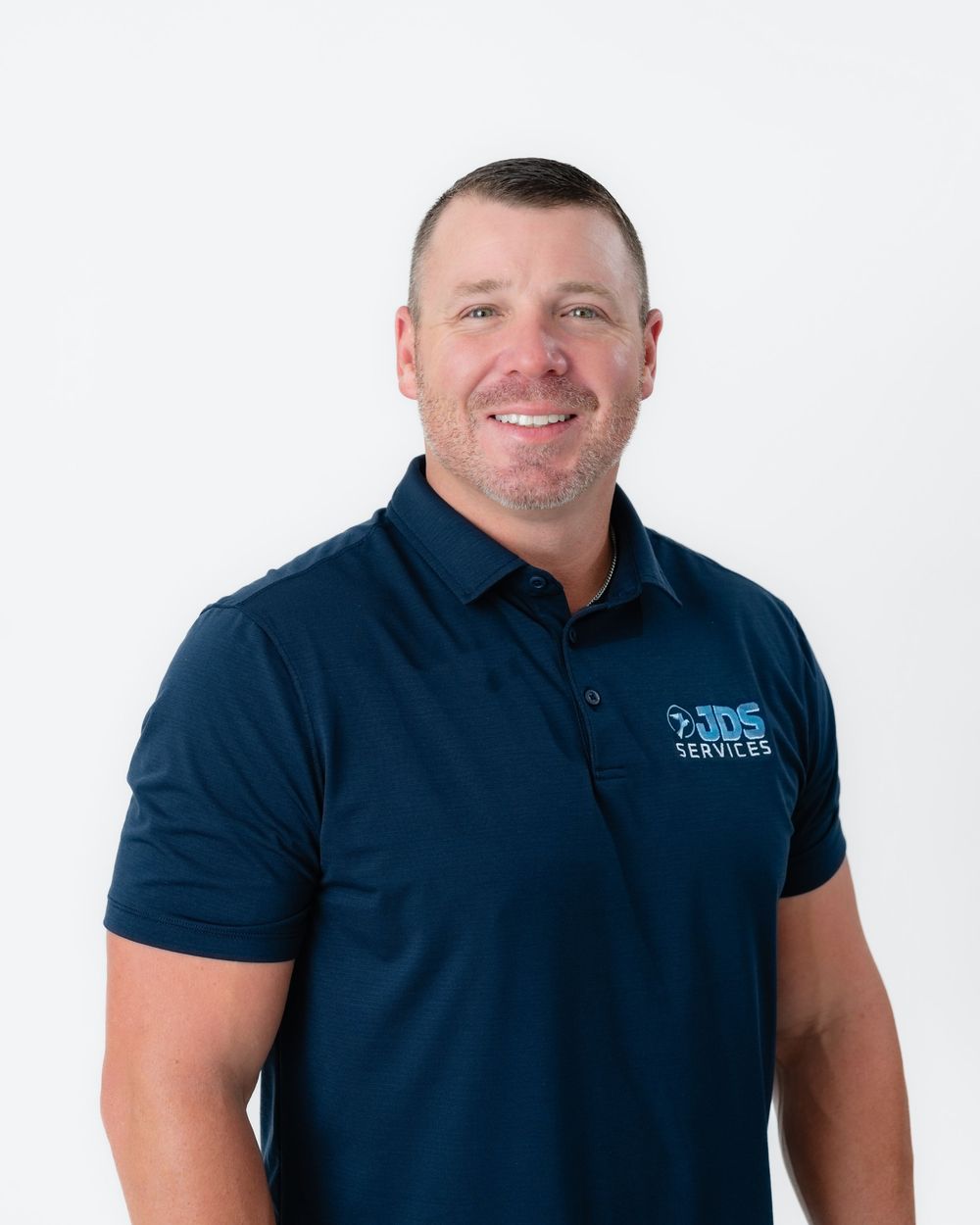 Person wearing a navy blue polo shirt smiles while posing against a white background in three similar poses.