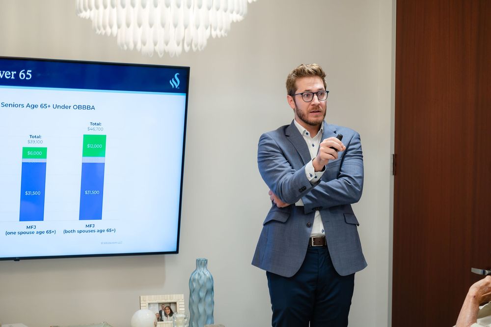 Business meeting presentation in modern office with people viewing data charts on large wall-mounted displays.