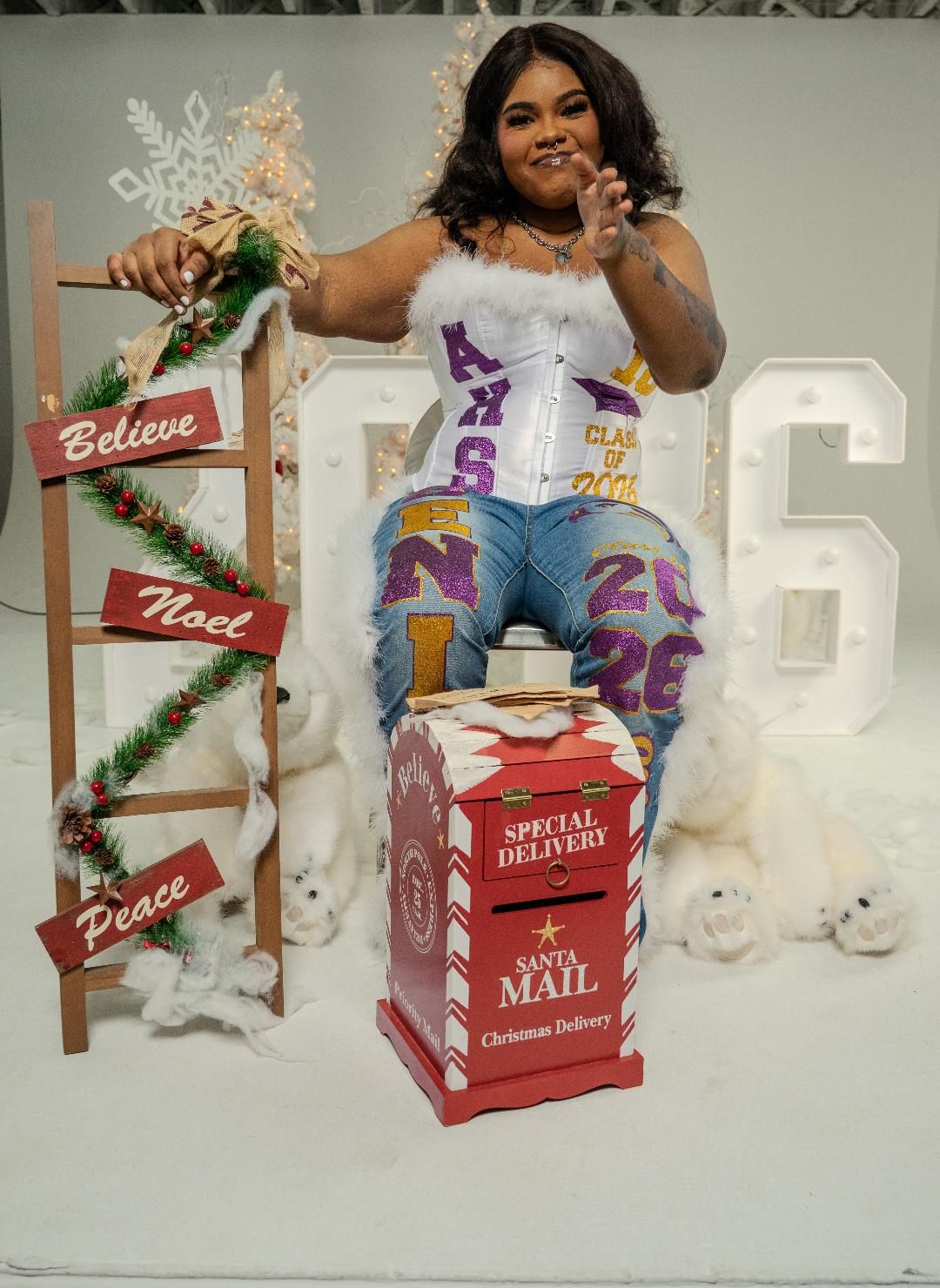 Holiday photo session setup with red mailbox prop, festive decorations, and white winter backdrop.