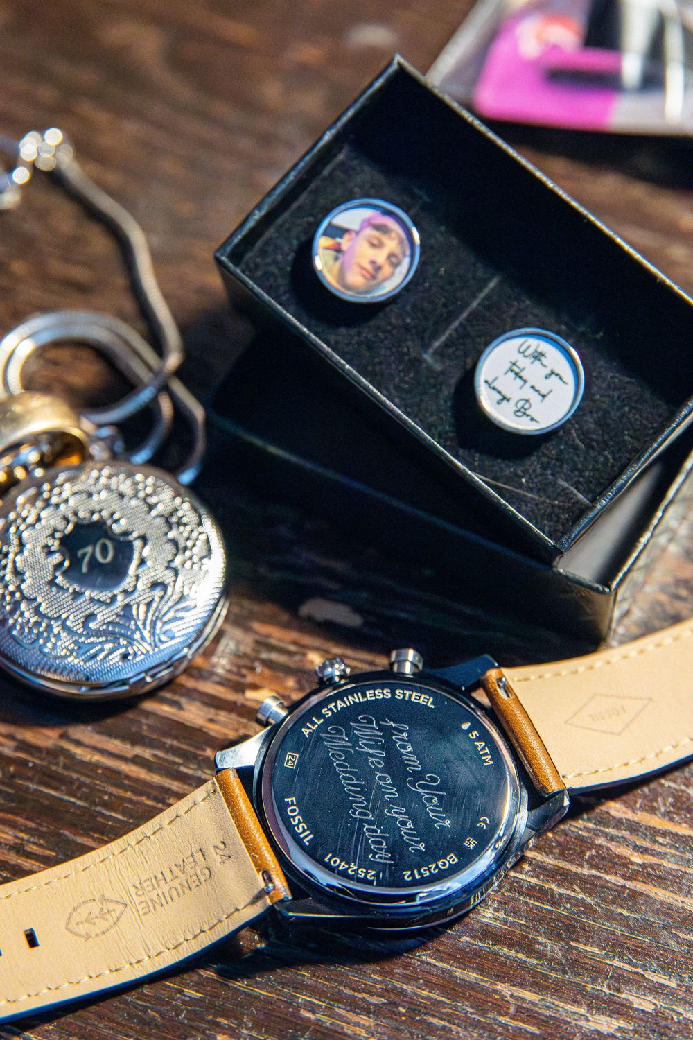 Close-up details of vintage pocket watches arranged on a rustic wooden surface.