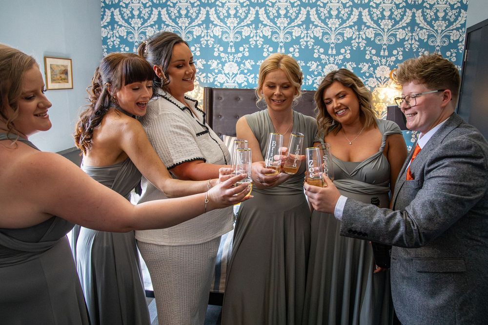 Wedding party toasting with champagne glasses in a celebratory moment.