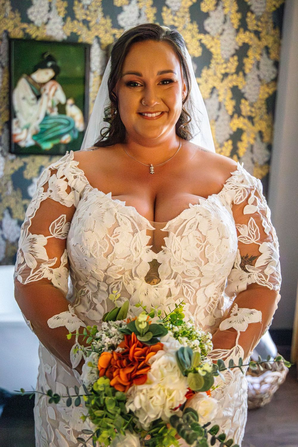 A beautiful lace wedding dress with intricate details and floral bouquet.
