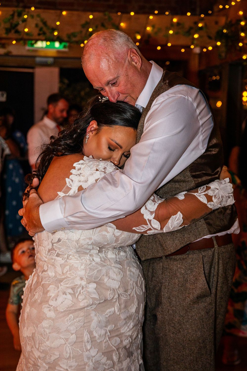 A tender moment shared during a wedding dance under twinkling lights.