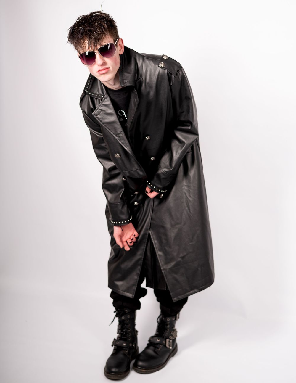 Gothic style outfit with black leather trench coat, combat boots and sunglasses.