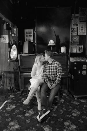 Black and white photo series of a couple sharing romantic moments in a dimly lit bar.