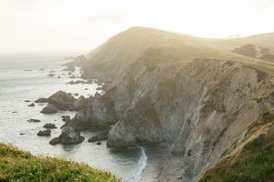 Panoramic view of dramatic coastal cliffs and rocky shoreline against the ocean.
