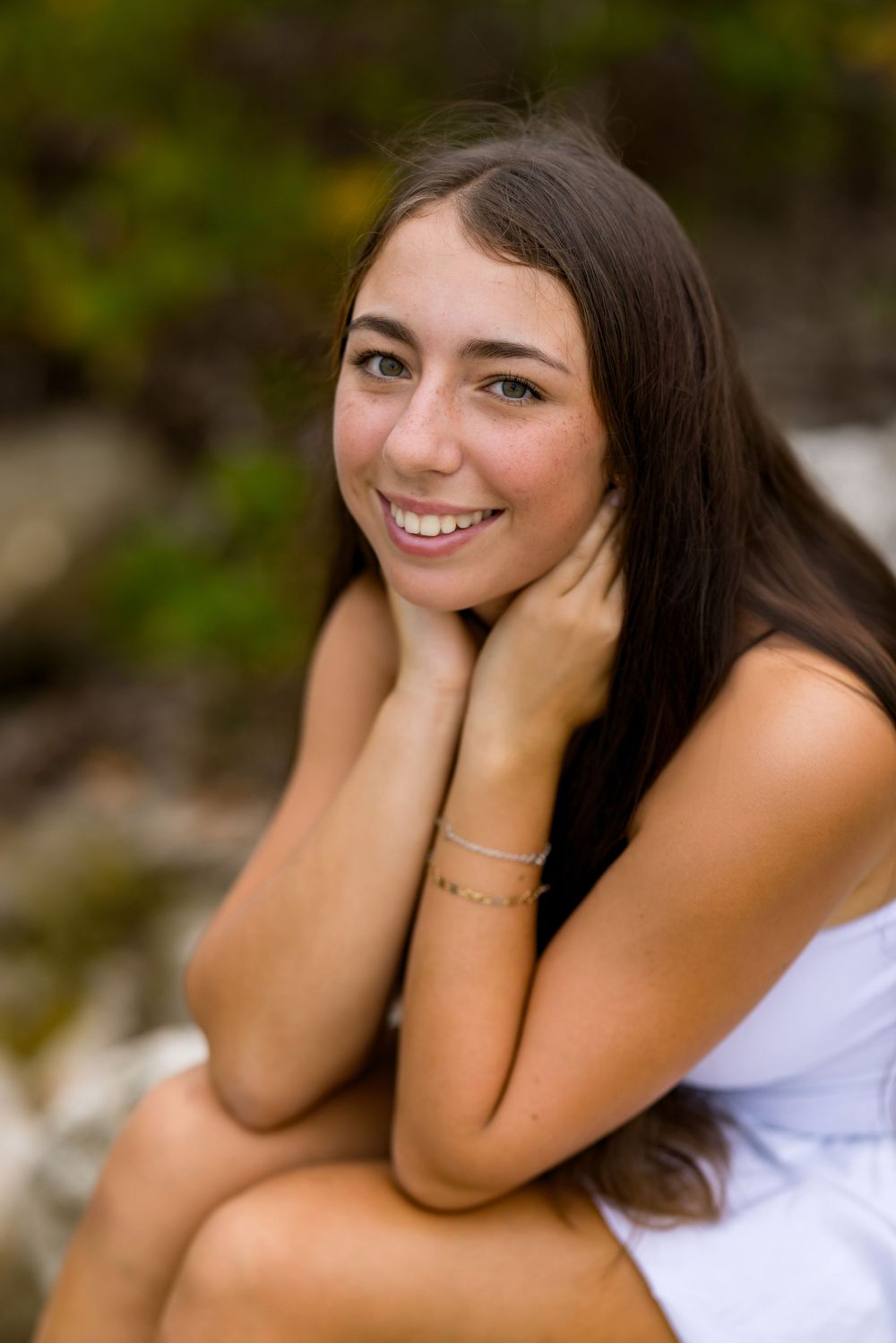 Portrait series showing playful expressions against natural green backdrop.
