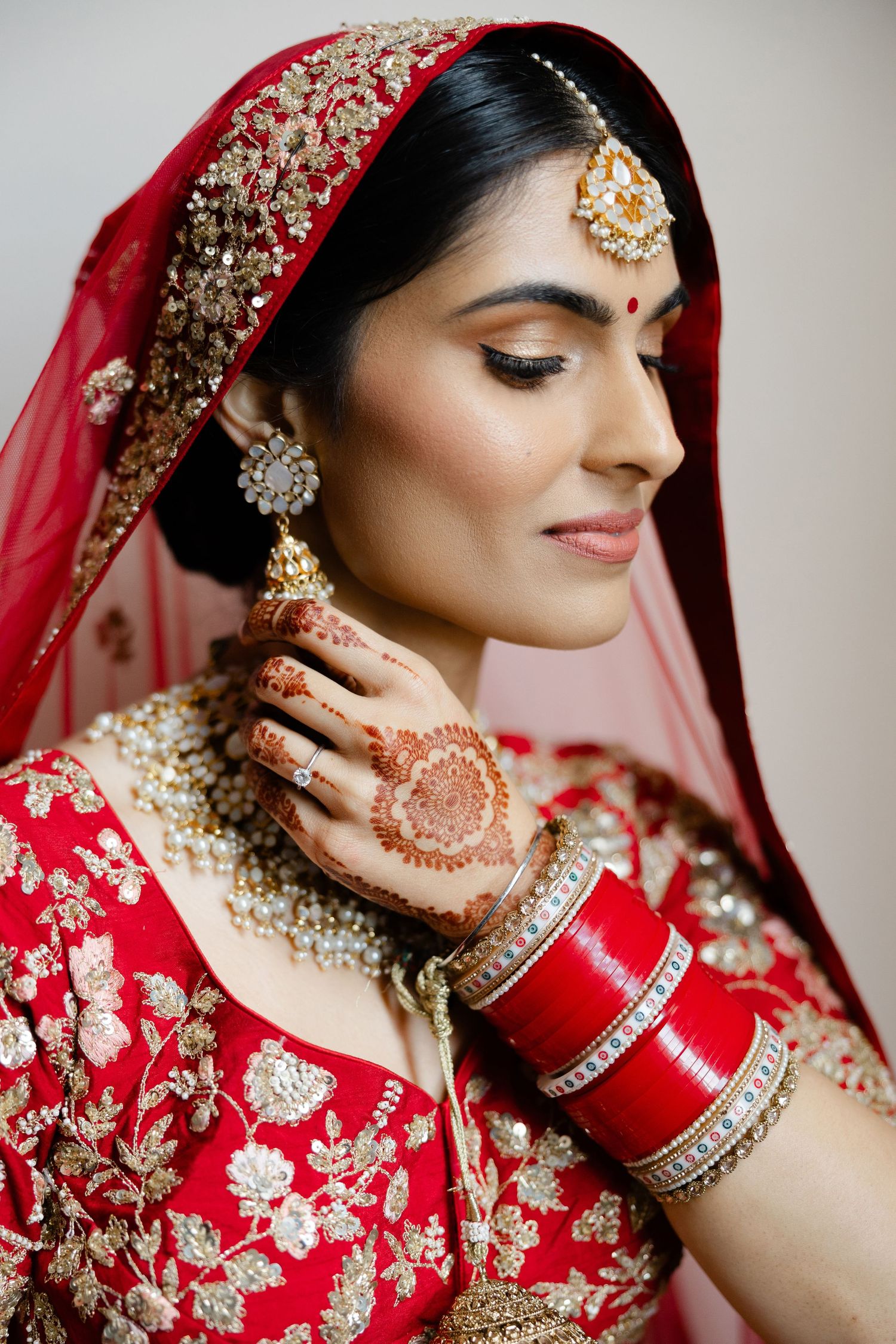 Closeup portrait of beautiful Sikh bride adjusting her earring
