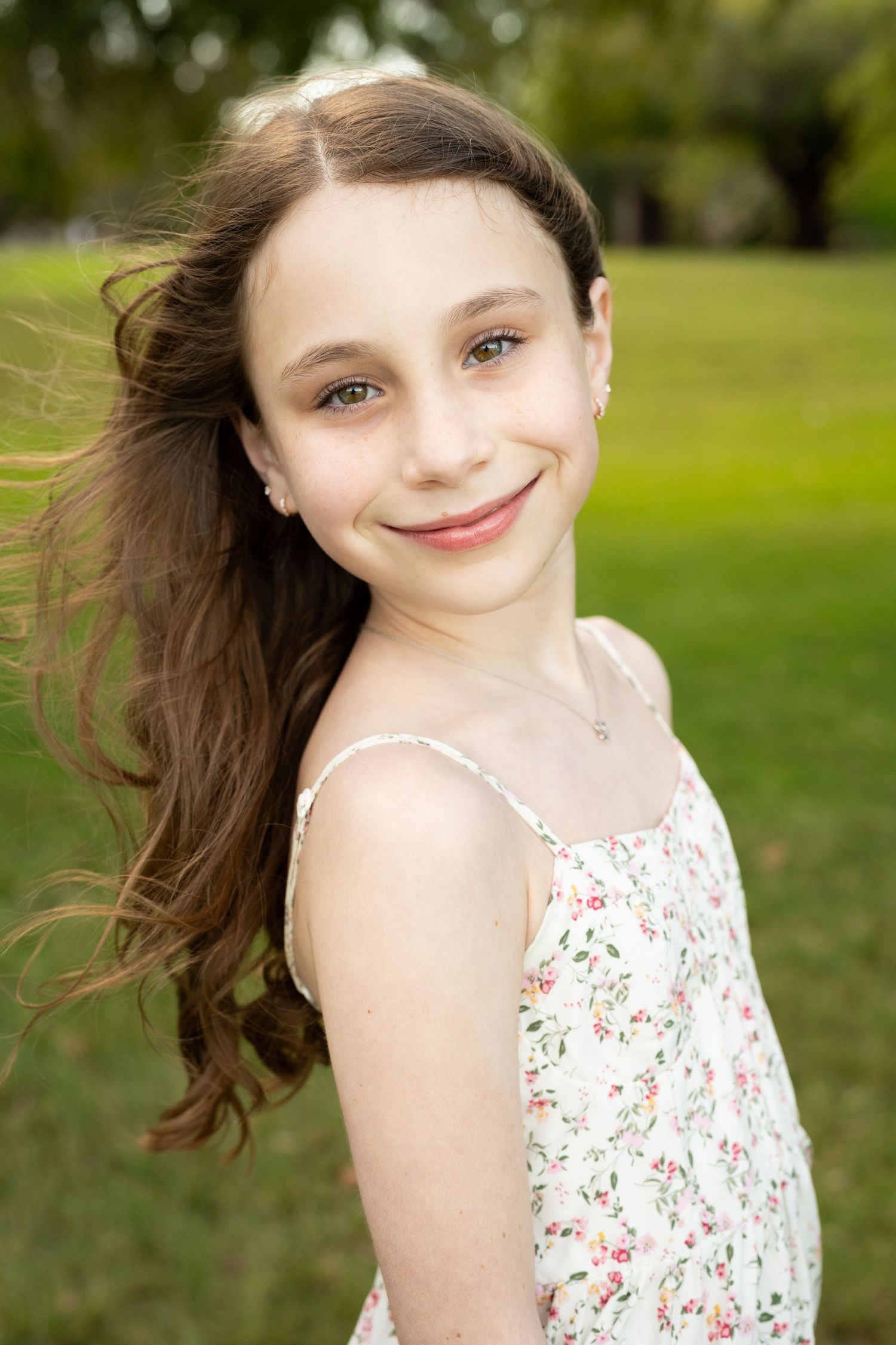 Portrait of a young girl in soft flattering light with windswept hair at an outdoor sunset family photography session in Perth