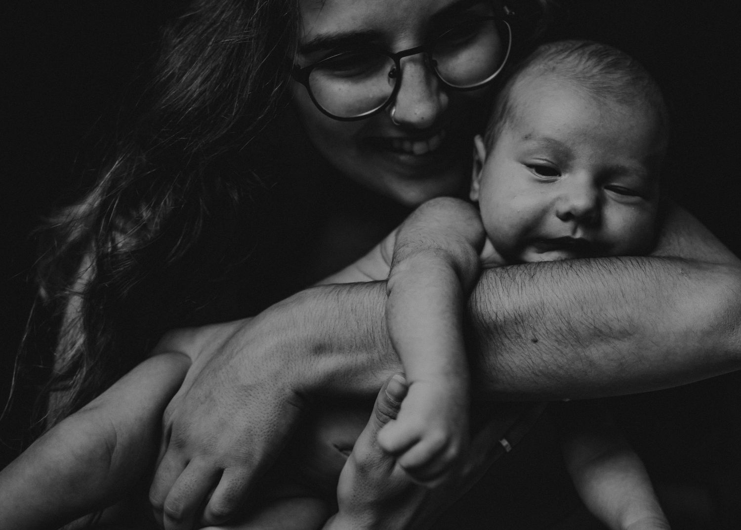 bebé primeiro mês em uma foto em preto e branco numa sessão fotográfica newborn casa em Portugal com a mãe que abraça e sorri