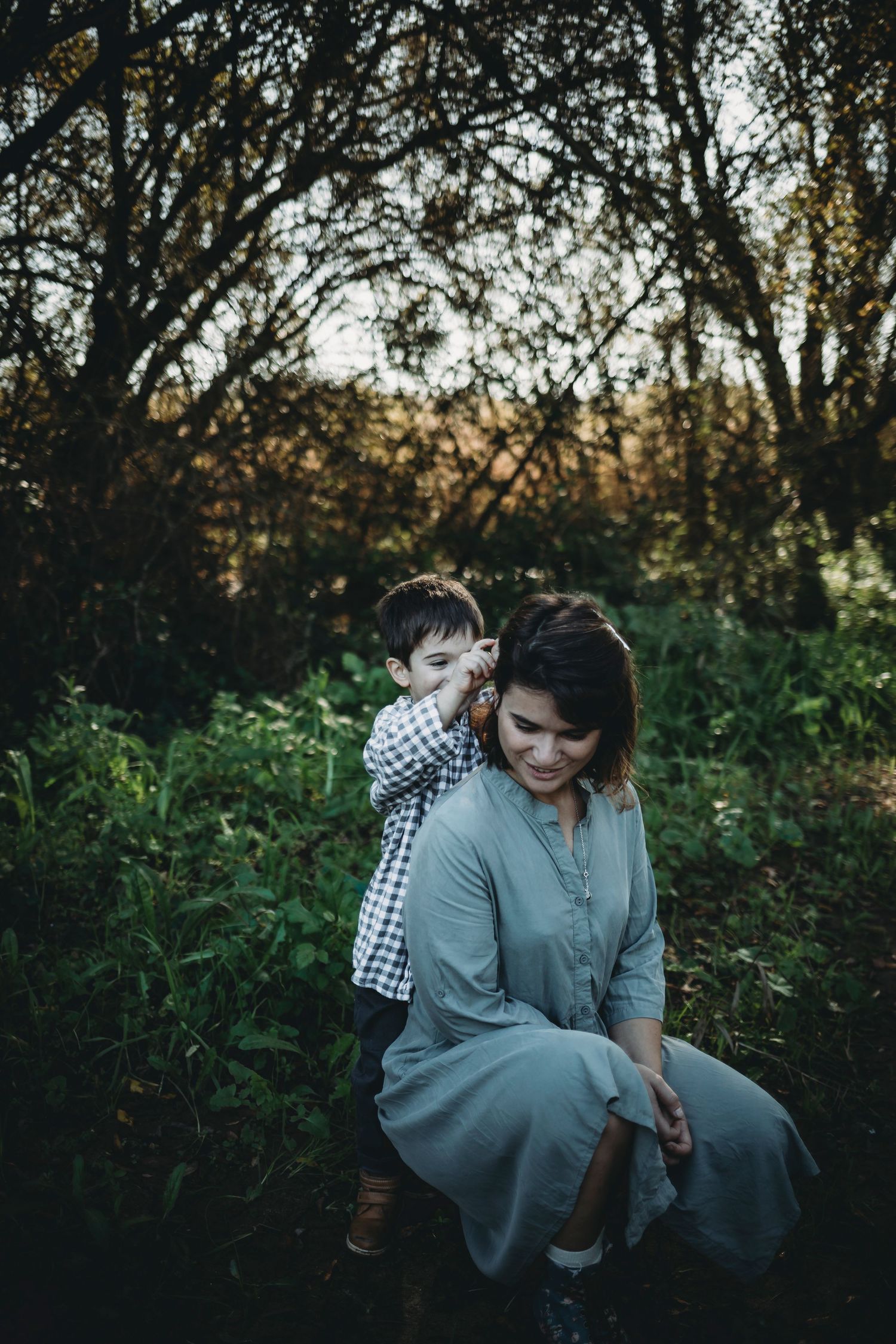 filho dá uma flor para a mãe  em sessão fotográfica de família na natureza em Portugal Caldas da Rainha