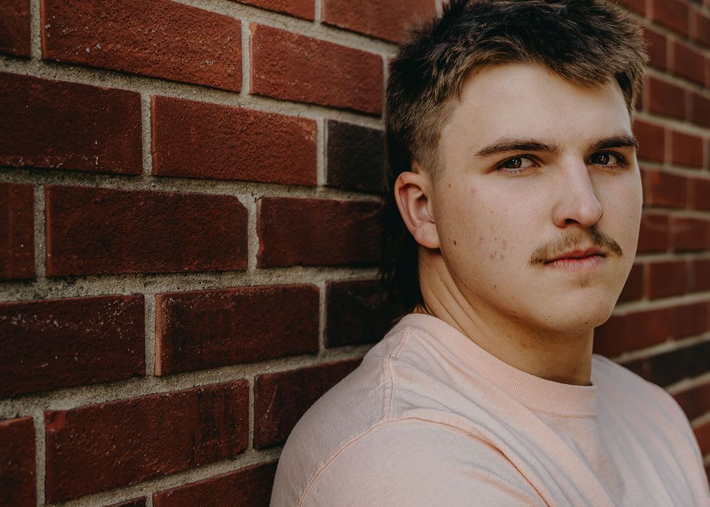 Senior Portrait against brick wall background wearing light colored t-shirt - Warsaw, Indiana