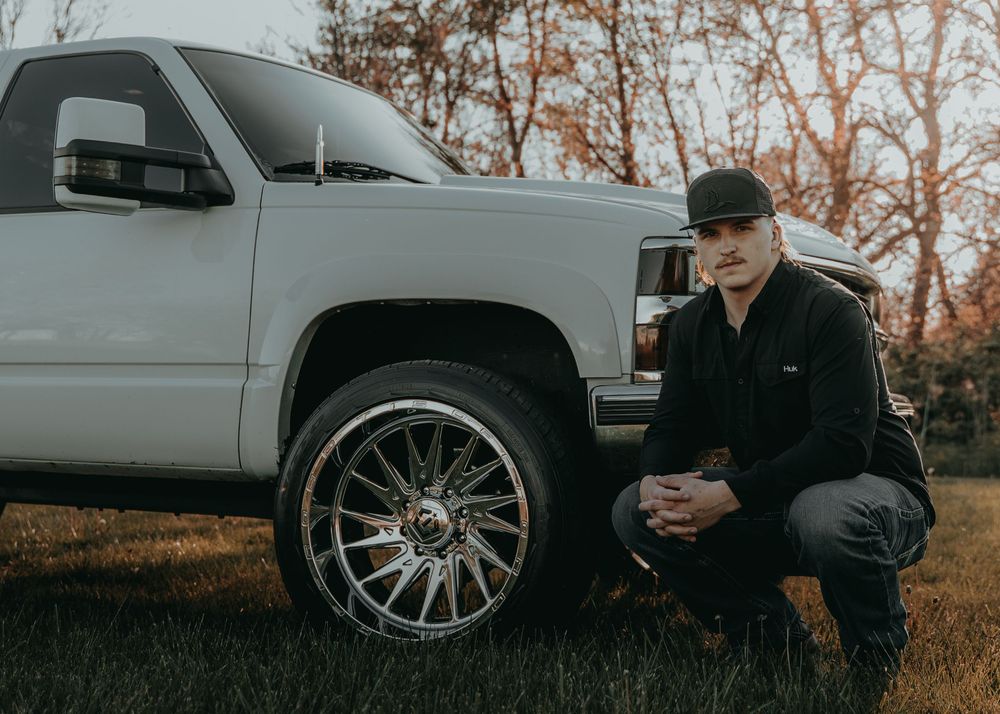 Senior Portrait next to pickup truck with chrome wheels photographed in autumn setting - Warsaw, Indiana