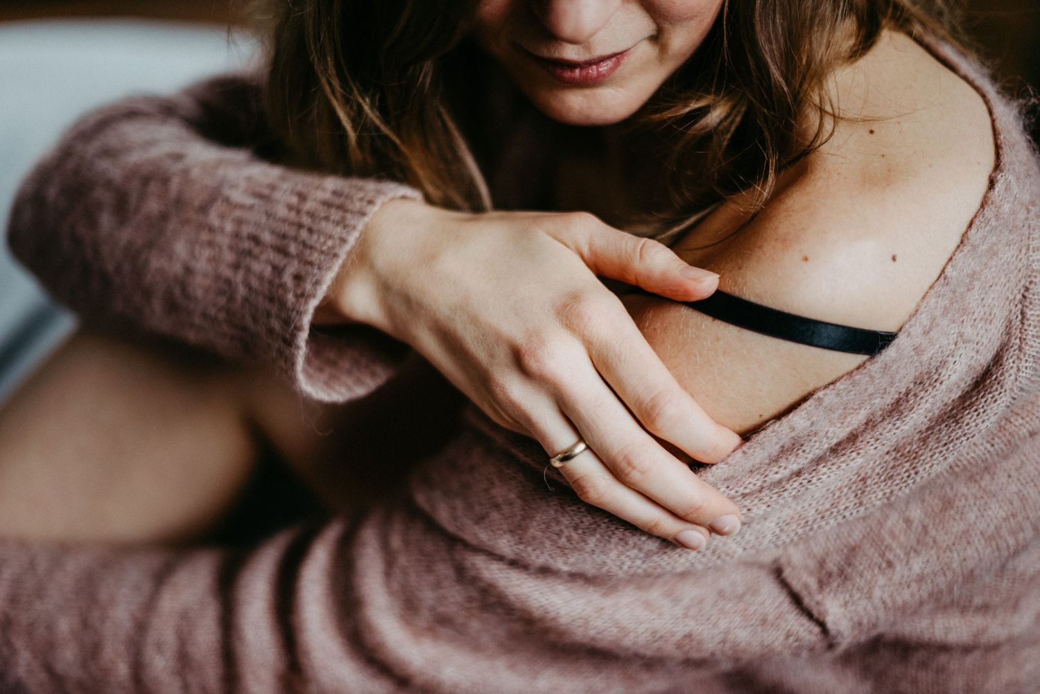 Boudoir Fotografie einer blonden Frau. Sie zeigt den Träger ihres BHs.