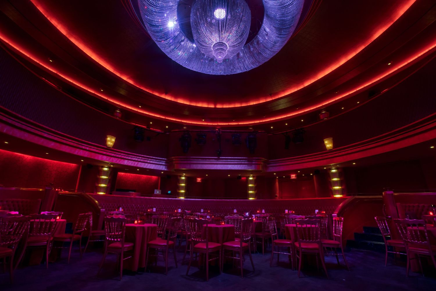 Modern nightclub interior with red LED lighting and blue disco ball creating atmospheric ambiance.