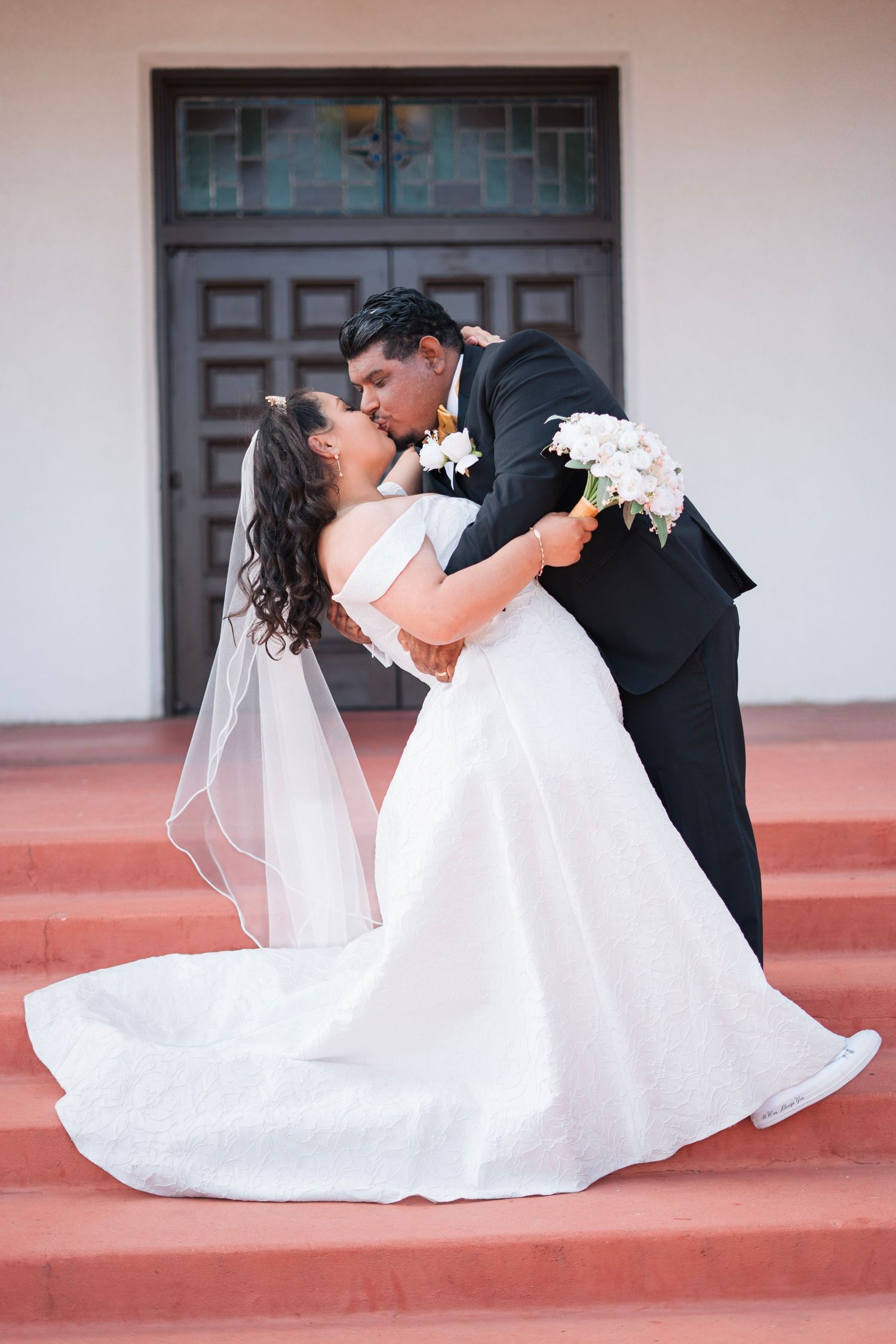Husband pulls wife down and gives her a huge kiss after just saying I do