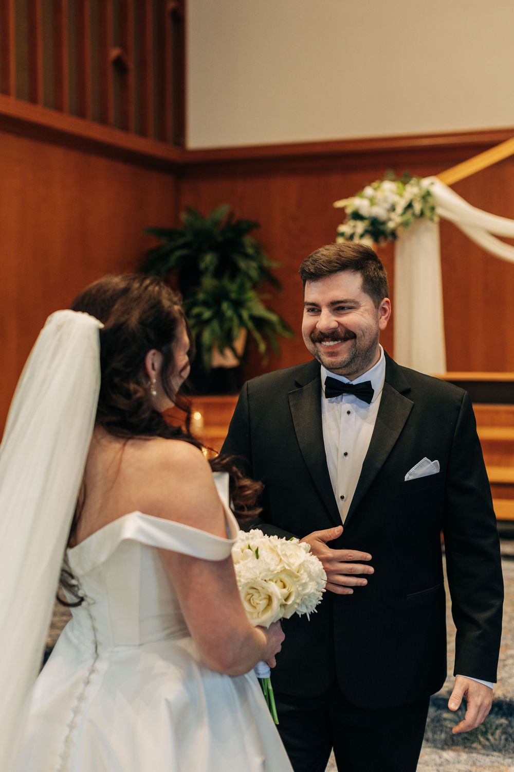 A joyful wedding couple shares a special moment during their ceremony in a church.