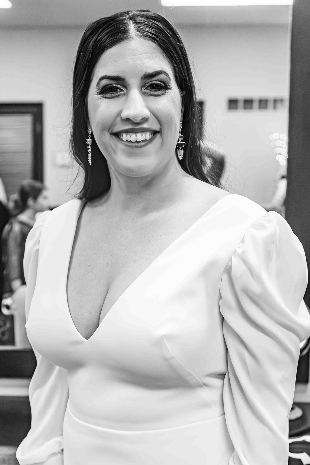 Black and white Portrait of woman bride in elegant white dress smiling brightly.