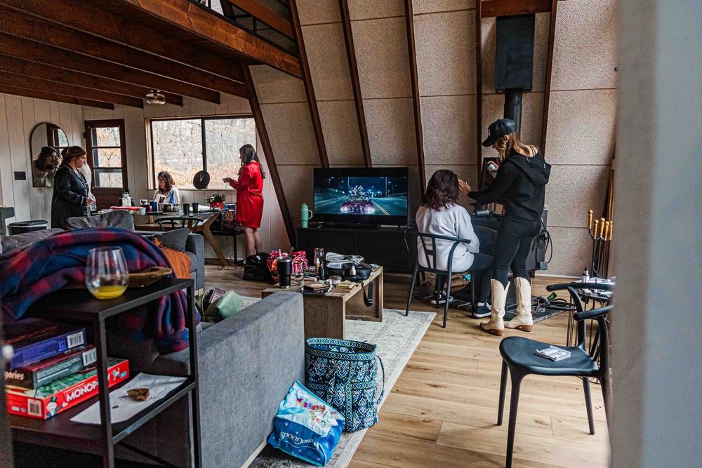Wide view of an A-frame room interior with bridal party getting ready at a house in Innsbrook, Missouri.