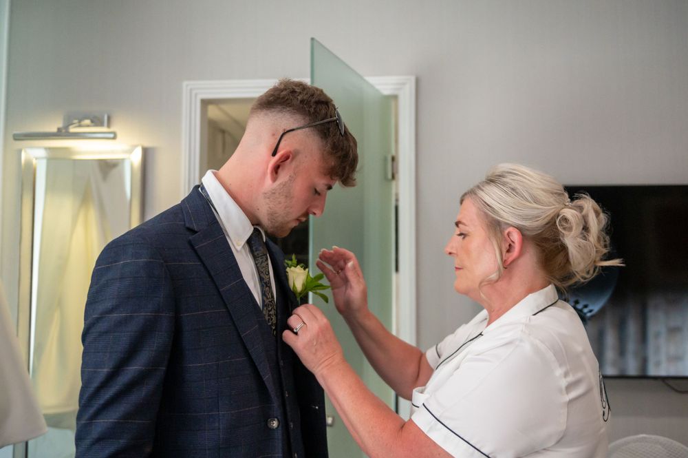 Bride putting flower on son