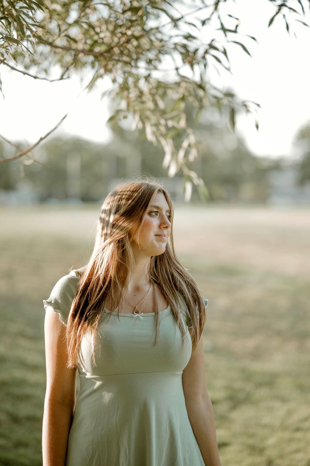 Dreamy outdoor portrait session in soft evening light with flowing hair movement.