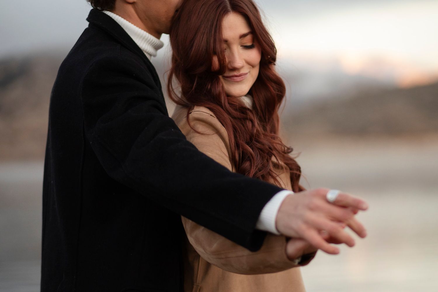 Couple holds hands playing on the shoreline.