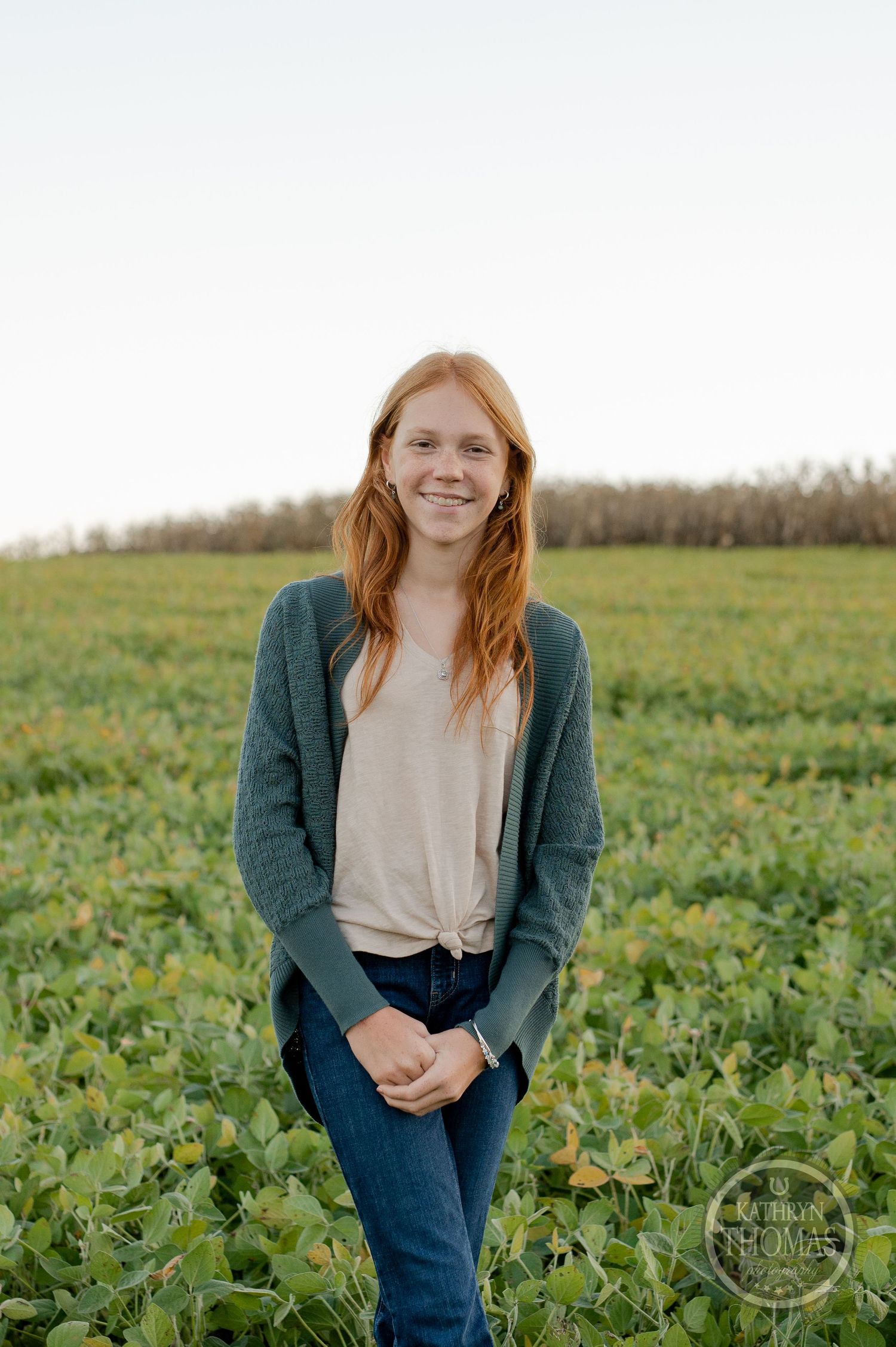 Portrait of someone standing in a green agricultural field wearing casual attire.