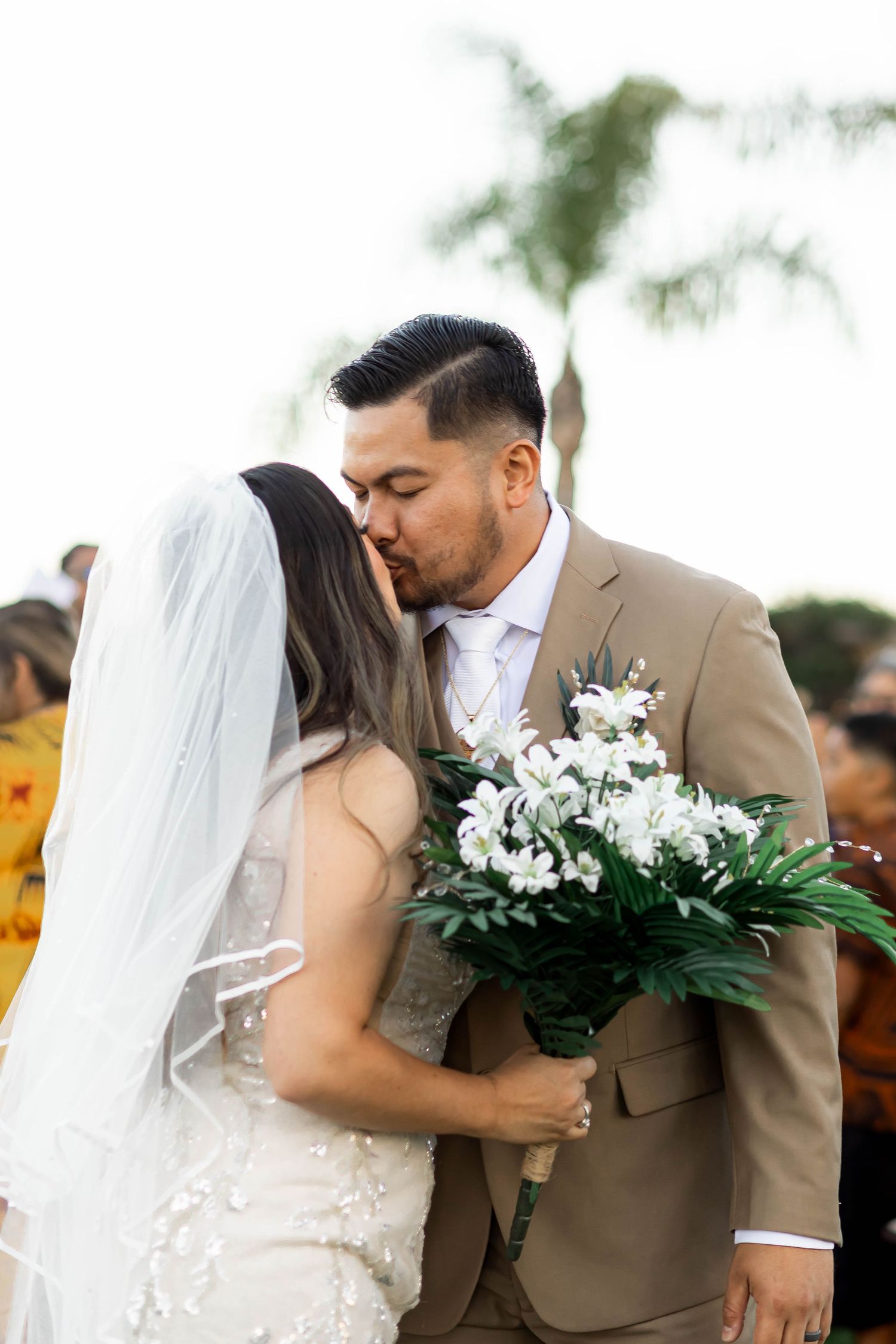 Wedding ceremony moments captured with white floral bouquet in natural setting.