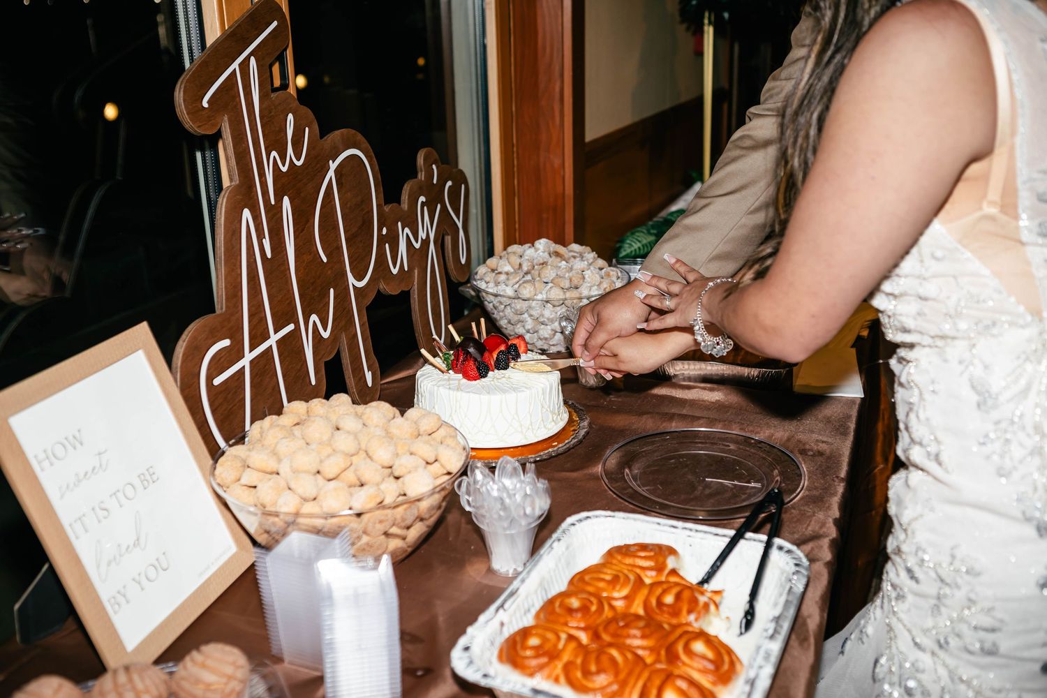 Wedding reception buffet table with various food dishes and decorative elements.