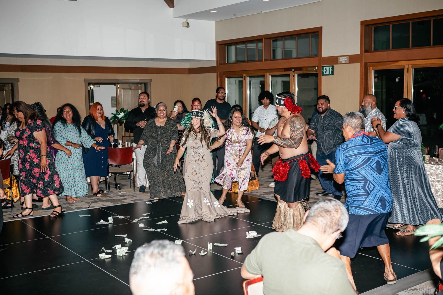 Large group of wedding guests dancing and celebrating on a dance floor.
