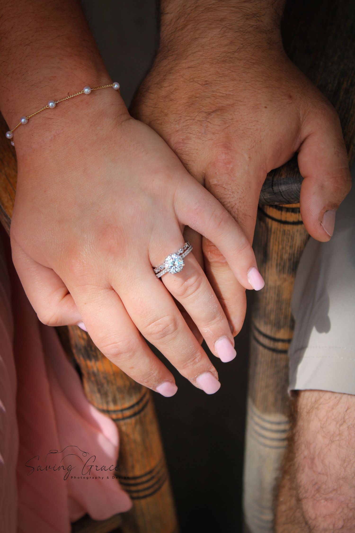 Close-up of hands showing engagement ring with French manicure.