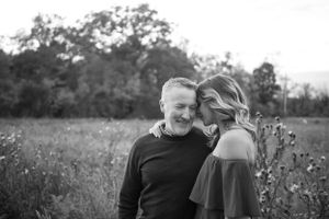 A tender black and white portrait of a couple sharing an intimate moment together in a wildflower meadow.