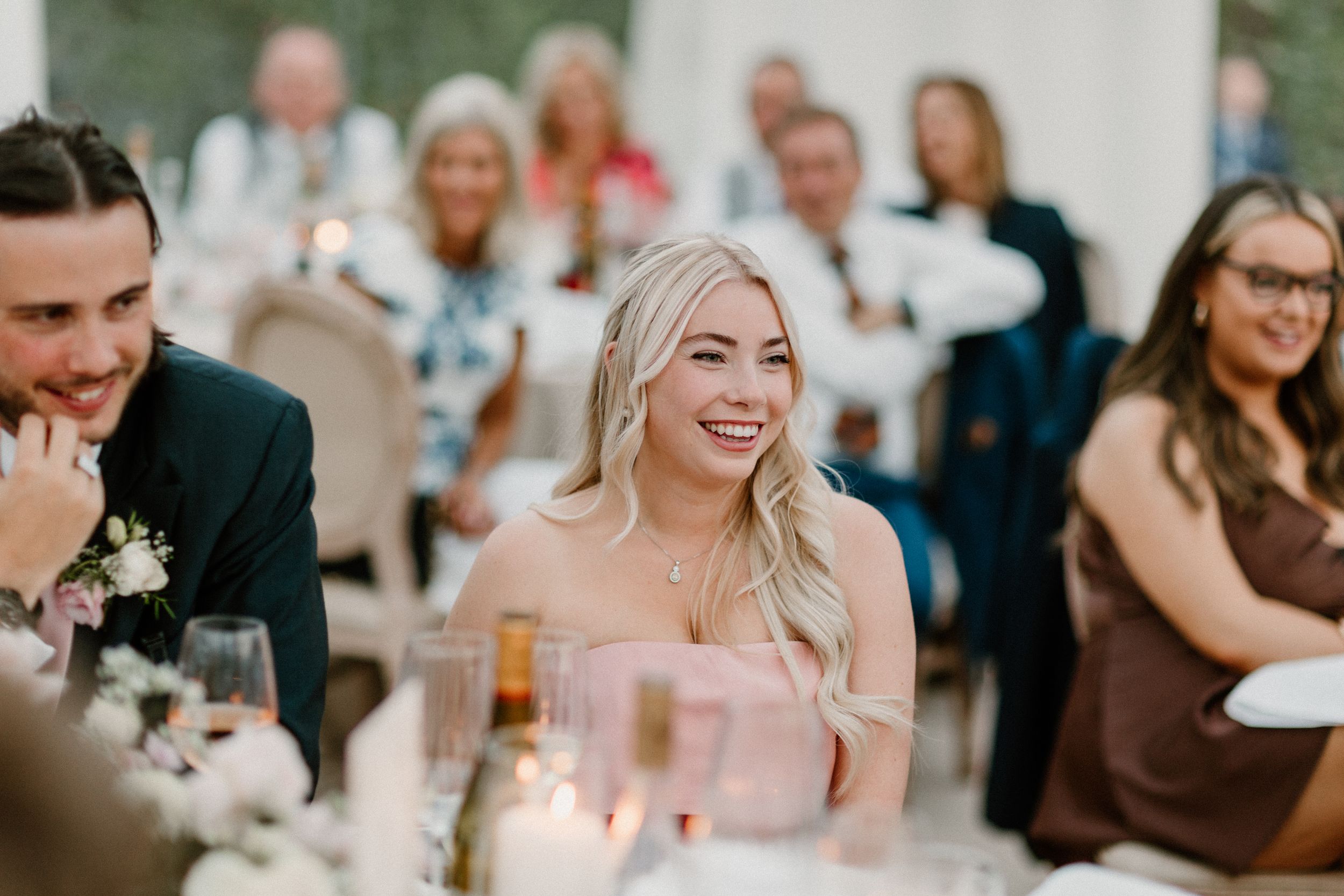 Wedding reception scene with guests dining at decorated tables.