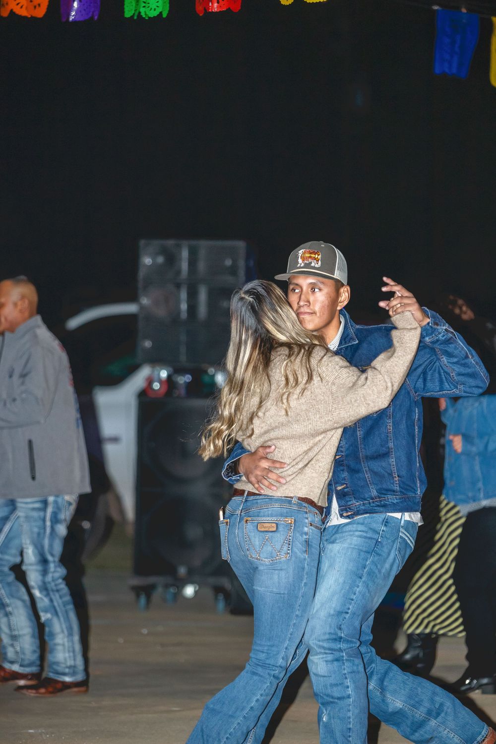 Couples dancing on an outdoor dance floor during a nighttime event.