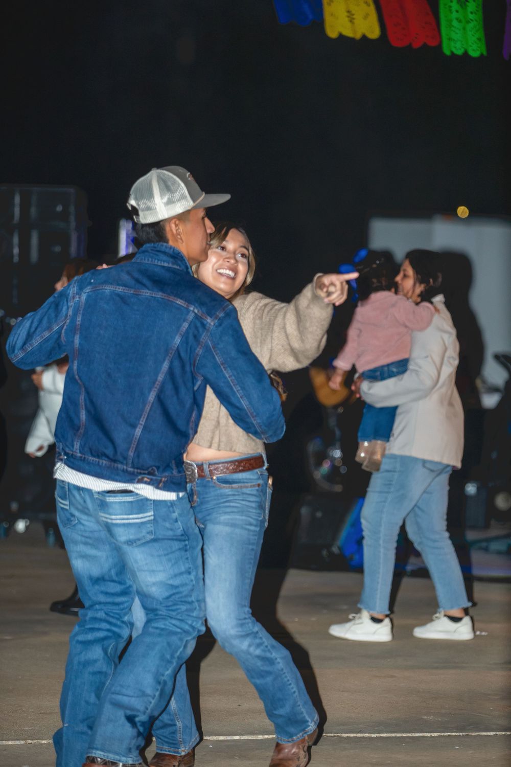People dancing together on an outdoor dance floor at a casual evening celebration.