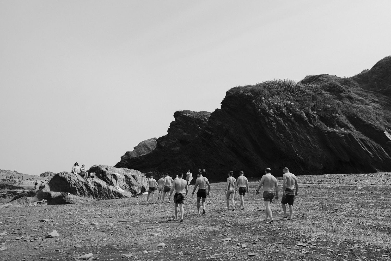 Groomsmen on morning of the wedding at tunnels beach wedding venue in north Devon, walking along the beach