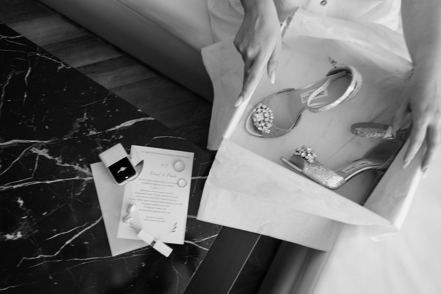 Flat lay black and white image of papers and a coffee cup on a marble surface.