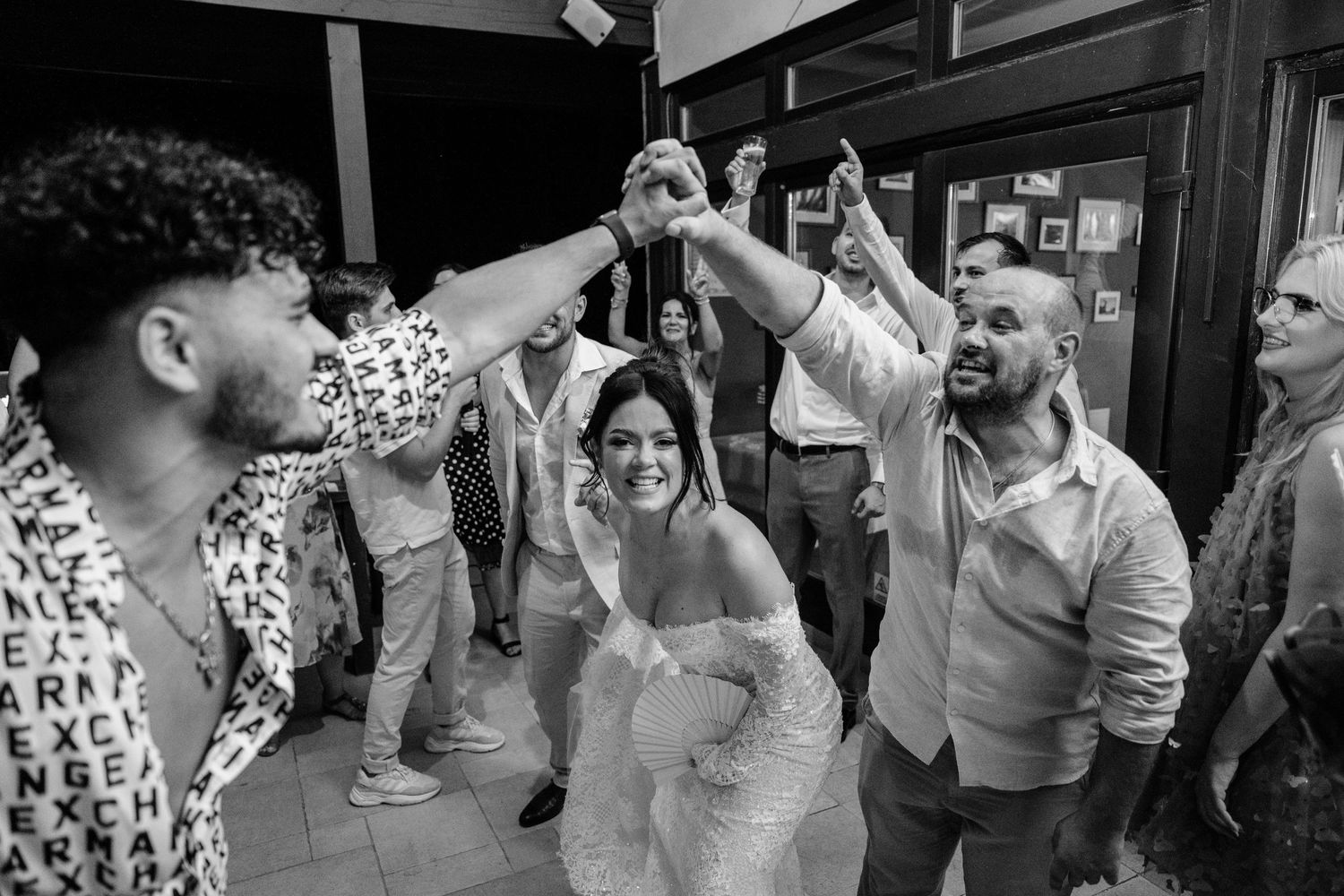 Wedding party celebrating and dancing during a lively reception party.