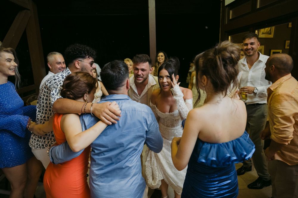 Wedding reception guests dancing and celebrating together in a lively group.
