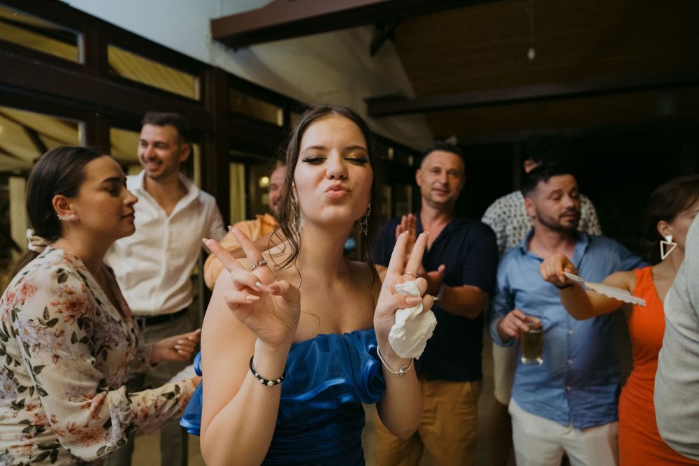 Party guests dancing and celebrating at a lively indoor event with festive atmosphere.