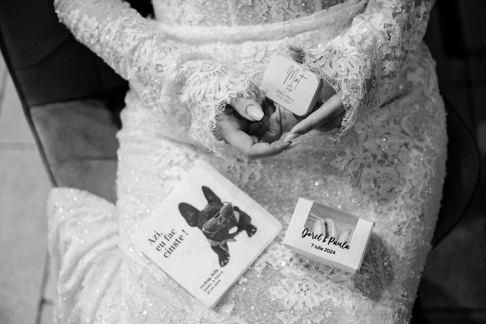 Close-up black and white detail of a lace wedding dress with playing cards visible.