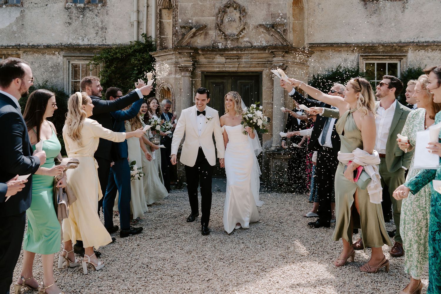 bride and groom walking through confetti tunnel at hasmwell house in bath