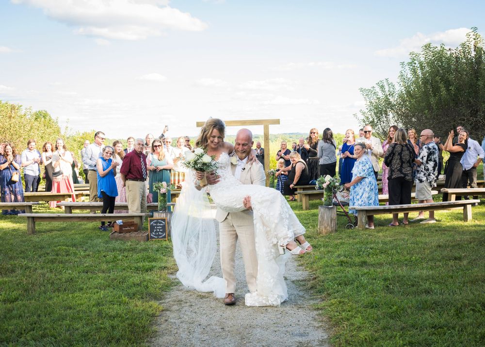Multiple images show guests celebrating at an outdoor wedding reception in a grassy field during golden hour.