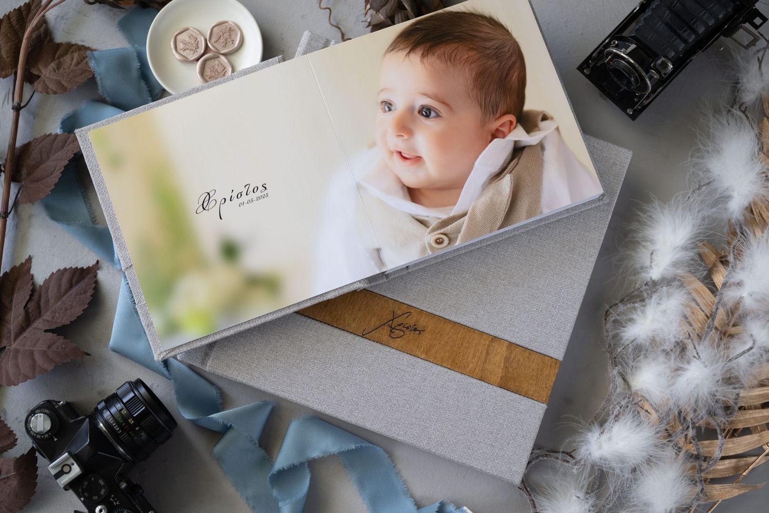 Wedding photo album with camera displayed on table with scattered dried flowers and decor items around it.