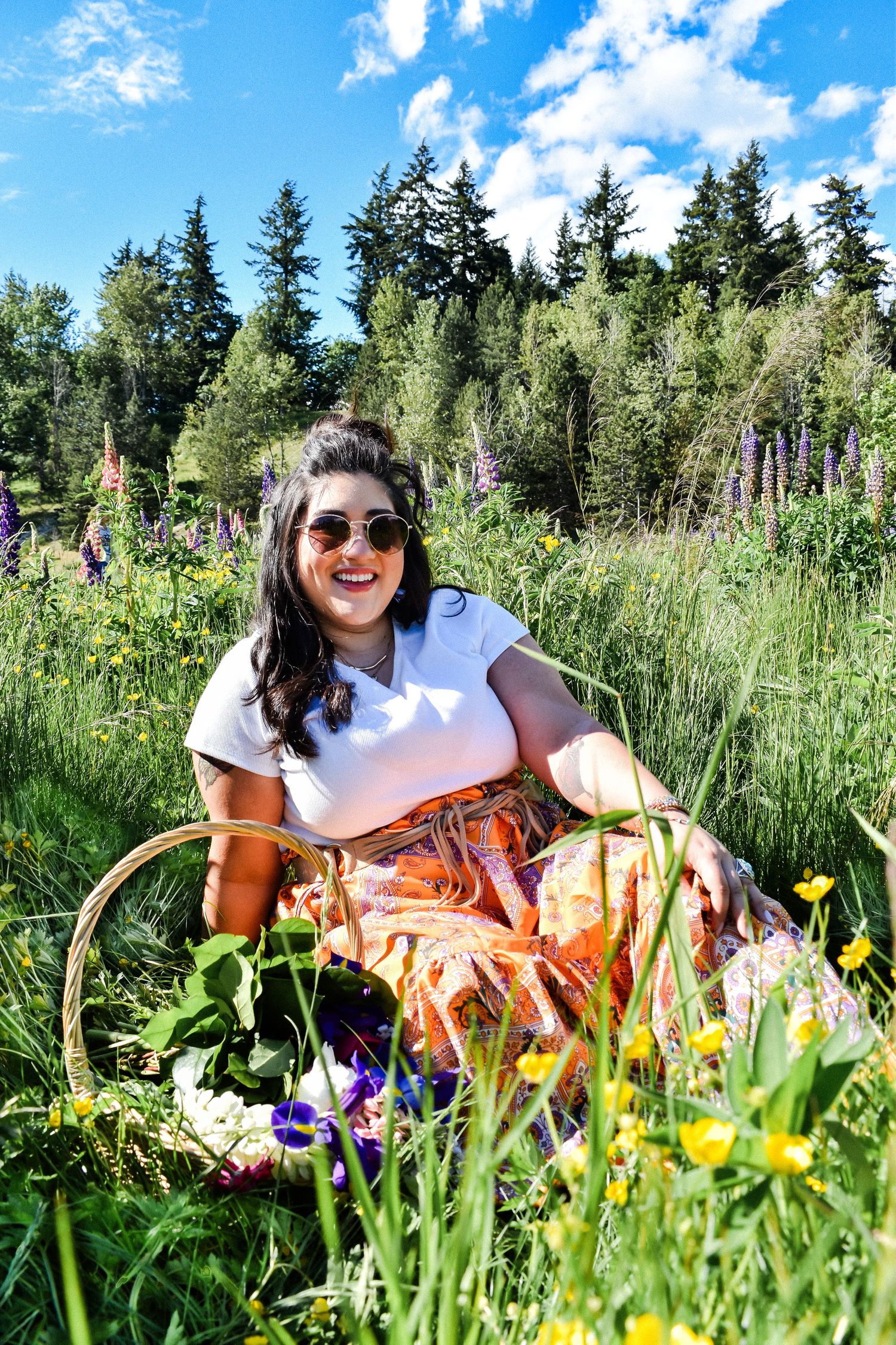 High school senior sitting in colorful flower field during outdoor portrait session in Seattle