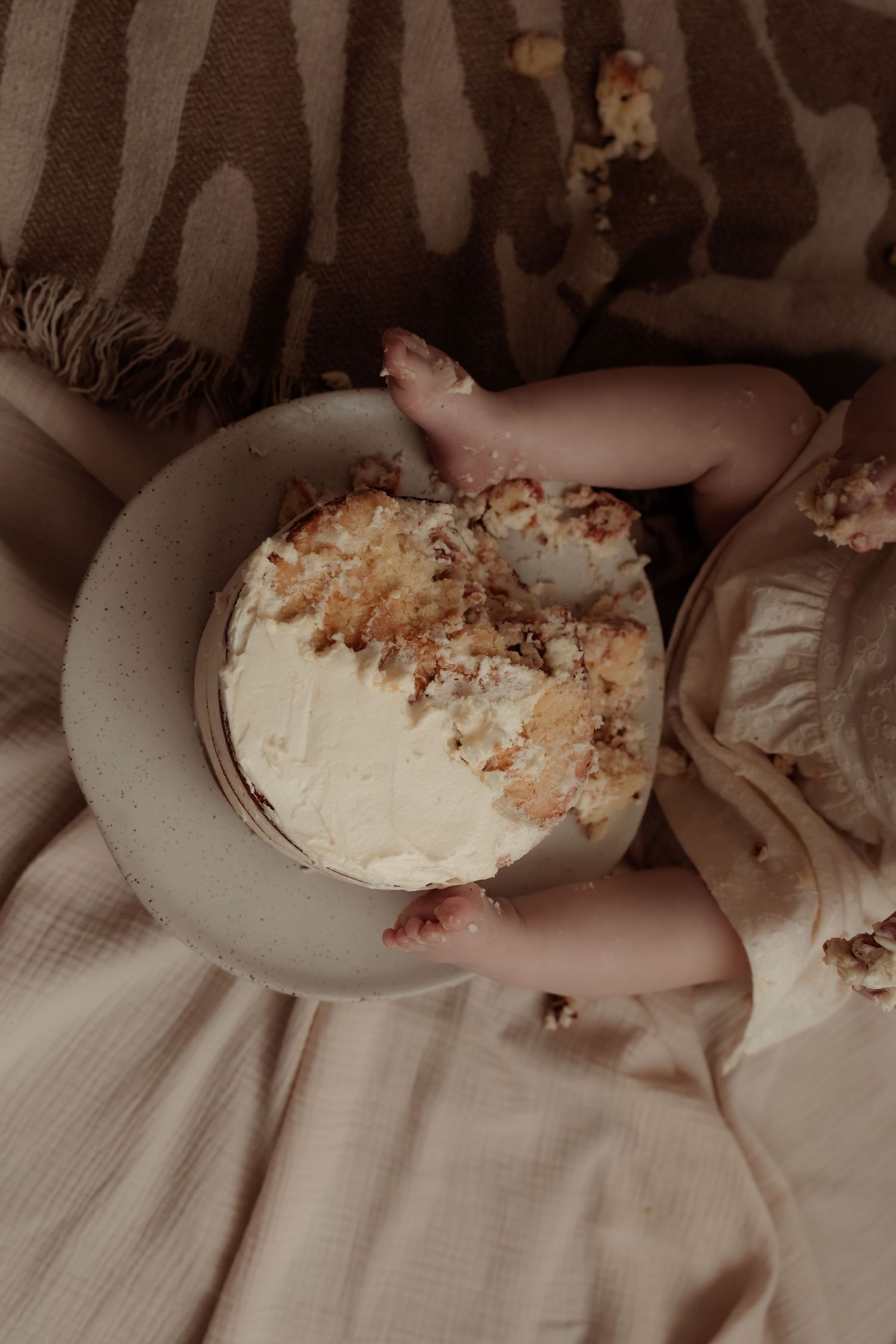 Detailfoto van babyvoetjes in decor tijdens cakesmash fotoshoot.