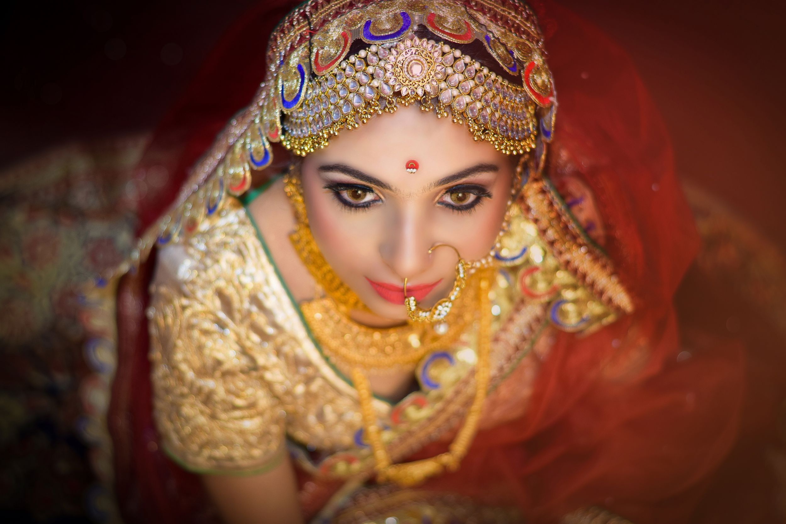 Vibrant red and gold traditional Indian bridal jewelry and attire showcased in a series of artistic portraits.