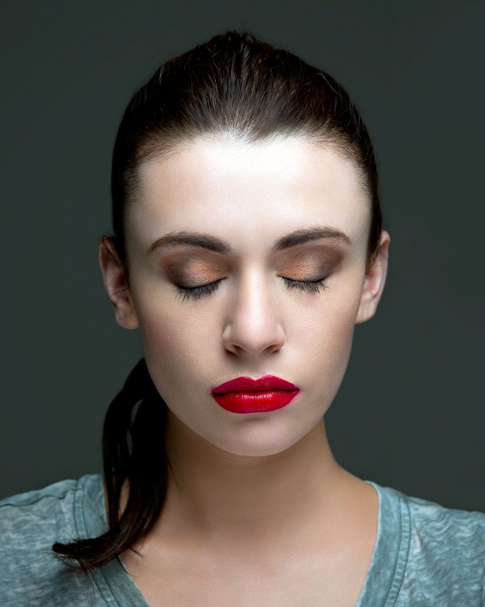 An artistic beauty portrait showing an ethereal lighting effect on someone wearing red lipstick and a blue top.